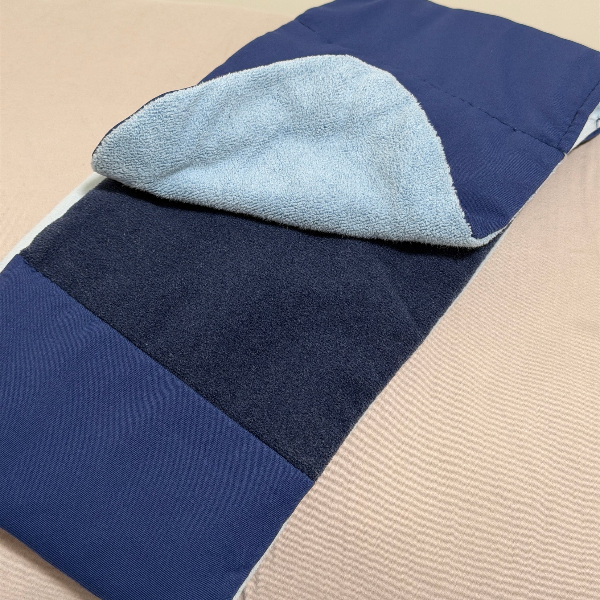 SomniGrave Weighted Sleep Mask folded to show quiet-touch adjustable closure with navy ice silk and light blue soft plush sides